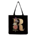 Black canvas tote bag with gold letter R and vintage floral print for daily shopping use. - Letter R Print (hm3239)
