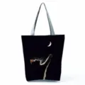 Détail de la magnifique sacoche noire arborant un joli design de chat mignon et lune. - Imprimé Silhouette Chat Touchant la Lune Fond Noir (hl6190)