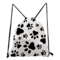 Close-up detail of white drawstring backpack featuring a black paw print pattern and black cords. - Black & White Geometric Paw Style (sk4383)