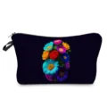 Gros plan d'une trousse de maquillage noire avec imprimé floral coloré et fermeture éclair. - Style hz9694
