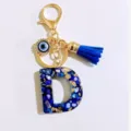 Exquisite blue letter D keychain featuring evil eye charm and leather tassel for daily use. - Letter D