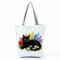 Close-up detail shot of the black cat watercolor print on the white canvas tote bag fabric. - Black Cat and Watercolor Flowers (hlk2481)