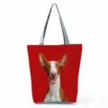 Nahaufnahme des Segeltuch-Tragetaschendetails mit lebendigem rotem Hundedruck und grauen Griffen. - Roter Hintergrund Hundedruck (hl7366) / Rot