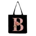 Black canvas tote bag featuring a pink letter B and floral print detail, foldable and washable. - Letter B Style (hmk2863)