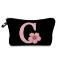 Detalle de bolsa cosmética negra con letra C rosa y estampado floral y cierre de cremallera. - Estilo Letras C Flores Rosas Fondo Negro