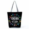 Detailed view of the black canvas tote bag featuring colorful handprints and teacher theme text. - Style Four (hl5392)