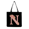 Gros plan sur le sac fourre-tout noir avec lettre rose N et impression de roses aquarellées. - Style Lettre N (hmk2875)
