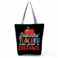 Detailed view of the black canvas tote bag featuring teacher theme apple graphic and text. - Style Twenty-Four (hl5412)
