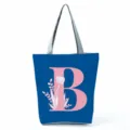 Blue canvas tote bag detailed view showcasing the pink letter B print and floral design. - Letter B