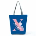 Blue canvas tote bag with pink letter X and floral print, large capacity shoulder bag. - Letter X