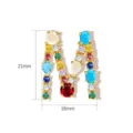 Detailed view of copper gold-plated letter M pendant set with colorful cubic zirconia. - Letter M / 21mm x 16mm
