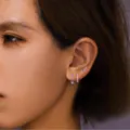 Detailed view of dainty silver-tone purple crystal stud earrings set worn on ear model. - Silver Tone Purple Rhinestone Style (款式15)