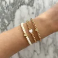 Chic set of three layered beaded bracelets with pearls and gold heart charms for daily wear. - Heart Charm Beaded Bracelet 3-Piece Set (41) / Three-Piece Set / Gold with White