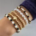 Elegant multi-layer beaded stretch bracelet set with gold metal and pearl charm details. - Artificial Pearl Stacking Set Style / Five-Piece Set / Gold Black and White