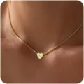 Dettaglio in primo piano di una delicata collana dorata con ciondolo a cuore e lettera. - Lettera A / Oro