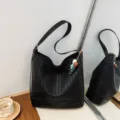 Woven leather bucket bag for women, stylish black shoulder crossbody handbag design. - With Pendant / Black