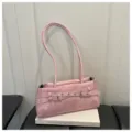 Rosa elegante Umhängetasche für Damen mit stylischen Ziergürteln sowie Metallösen. - Rosa
