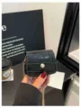 Nahaufnahme einer trendigen schwarzen Mini Krokomuster Umhängetasche mit goldener Kette. - Schwarz