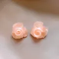 Nahaufnahme Detailaufnahme von hellrosa Harz Rosenblüten Ohrringen mit zartem Design. - Rosa