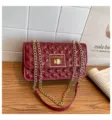 Red patent leather quilted chain shoulder bag with gold hardware and chic flap design. - Red