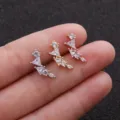 Gros plan détaillé de boucles d'oreilles incurvées en zircone aux trois coloris métalliques. - No.6 Style Cluster Géométrique / 0.8x6mm / Argent