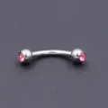 Close up view of surgical steel curved barbell eyebrow piercing ring with pink crystal gems - 1.2*8*3mm / Pink