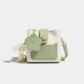 Sac seau élégant pour femme en couleur contrastée, petit sac bandoulière stylé avec pendentif. - Vert