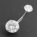 Close-up detail of 316L stainless steel curved navel ring with sparkling cubic zirconia. - Silver White