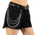 Close-up of punk style multi-layer metal chain with spike pendants and black grommet belt. - Silver