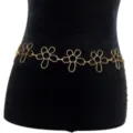 Gold metal flower waist chain detail showing delicate hollow floral links and adjustable fit. - Gold