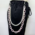 Close-up detail of the dual-layer pearl and pink acrylic pants chain hip hop style. - Pink