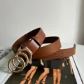 Brown leather belt featuring a chic triple gold-colored ring buckle, perfect for styling. - Camel
