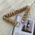 Gold metallic elastic waist belt detail, featuring stretchy ruched design and stylish metal buckle. - Gold