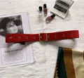 Detailed shot of red wide belt with metal buckle, stylish fabric accessory for dresses and coats. - Red