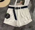 Detail view of white denim shorts with trendy canvas belt and hexagonal buckle design. - 105cm / Navy Blue