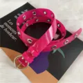 Close up view of hot pink transparent PVC belt with metal eyelets and round buckle detail. - Rose Red