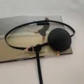 Vista di dettaglio ravvicinata di cintura in pelle nera con borsetta rotonda e fibbia dorata. - Solo marsupio / Nero
