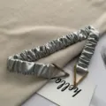 Metallic pleated elastic waist belt with modern metal triangle buckle detail close up view - 65cm / Silver