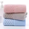 Close-up detail of soft absorbent cotton face towels in pastel colors with woven texture. - Pink