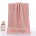 Nahaufnahme eines weichen rosa Baumwollgesichtstuchs mit elegantem gewebtem Rand für den Alltag. - Kletter-Stil Rosa