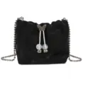 Trendy black velvet bucket bag featuring chic metal chain strap and decorative beaded drawstring. - Black
