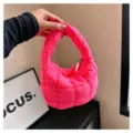 Detailed view of bright pink quilted mini cloud handbag, modern puffy handle texture. - Rose Red