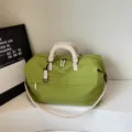 Grote groene reistas weekendtas met witte handvatten en schouderriem voor fitness. - Groen