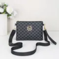 Detailed view of black monogram crossbody bag with zipper closure and adjustable shoulder strap. - Black