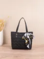 Black quilted tote bag detail shot showing chic chain print scarf handle accent and spacious design. - Black