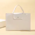 Minimalist white laptop handbag detail view, elegant business briefcase style with front pocket. - White