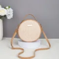 Detail view of the round straw woven crossbody bag, featuring textured beige straw and brown strap. - 17*6*17 / Apricot