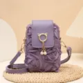 Lila Handytasche mit Rosen, Katzenohr-Metallring und eleganten Perlenquasten-Details. - Lila