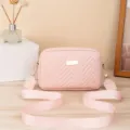 Detailansicht der rosa gesteppten Umhängetasche mit Zickzackmuster und breitem Riemen. - Rosa