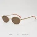 Gros plan de petites lunettes de soleil en metal vintage ovales avec verres marron et embouts. - Or mat avec verres marron C2